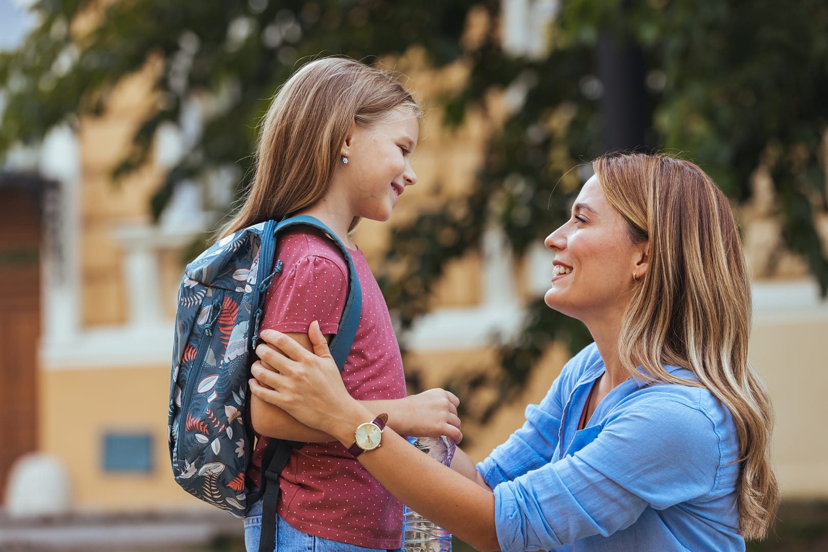 Mother dropping off her young daughter at school.