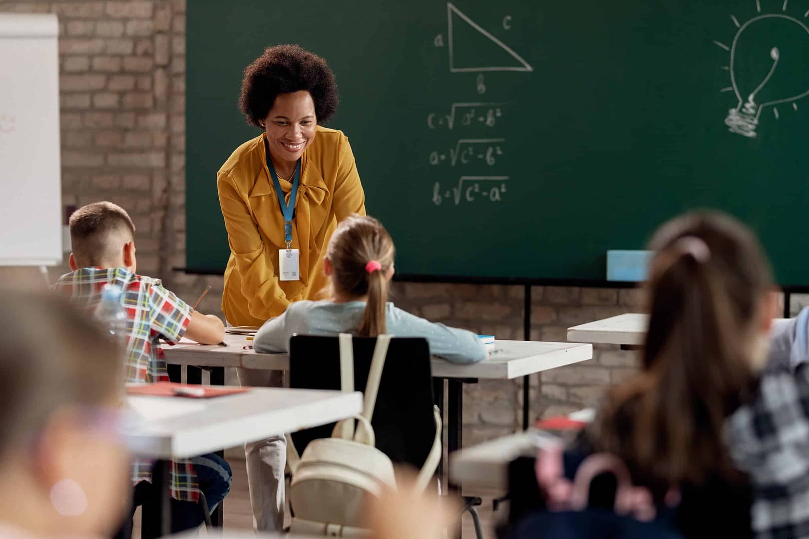 Teacher talking to student in a classroom while wearing her CrisisAlert badge.