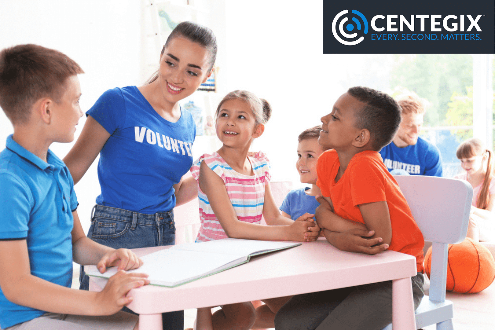 Group of young students gathered around a table with a young woman volunteer.