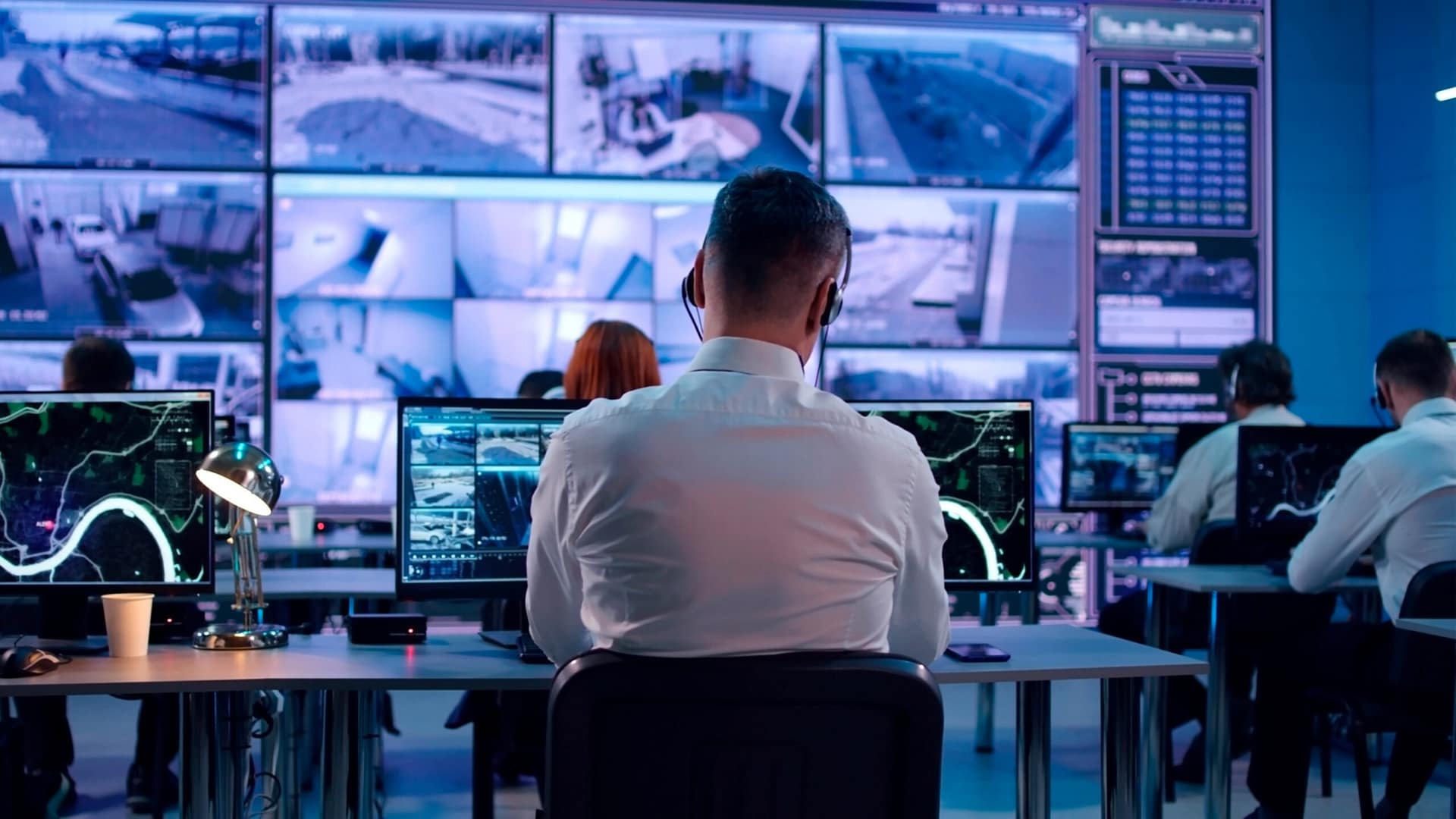 Male spy browsing video and map on computers
