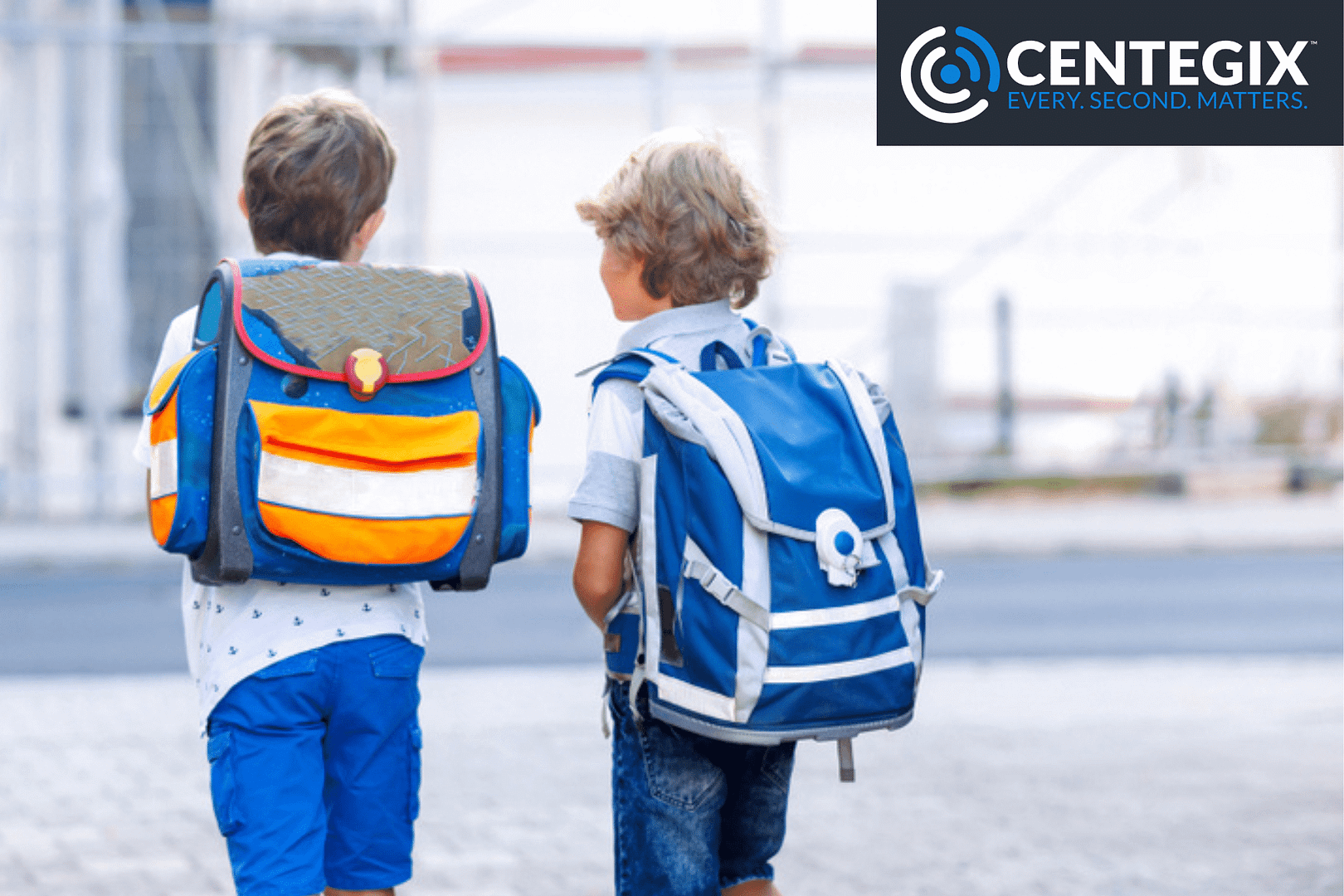 wearable emergency button Two young boys wearing backpacks walking outside, safer because of CENTEGIX wearable emergency button